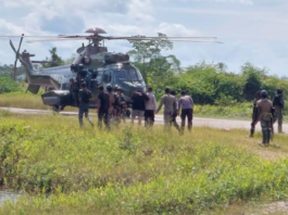 Indonesian military and police personnel surround a helicopter in Kenyam district, Nduga regency, Papua Highlands, in February