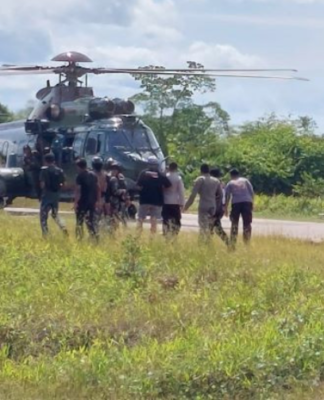 Indonesian military and police personnel surround a helicopter in Kenyam district, Nduga regency, Papua Highlands, in February