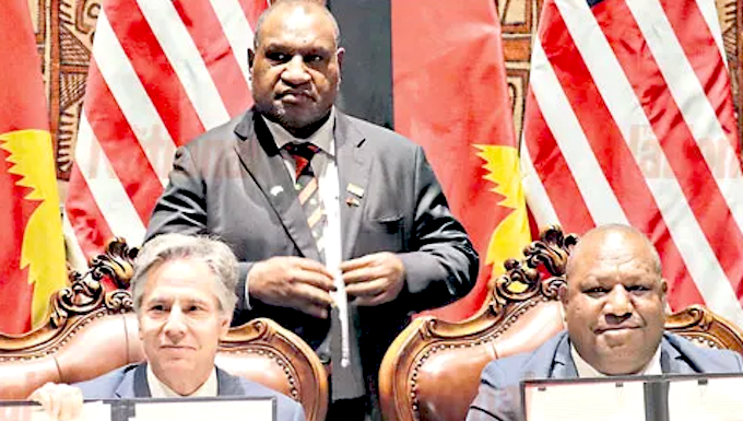 US Secretary of State Antony Blinken (from left), PNG Prime Minister James Marape (standing) and Defence Minister Win Daki after signing the US-PNG defence cooperation pact in Port Moresby