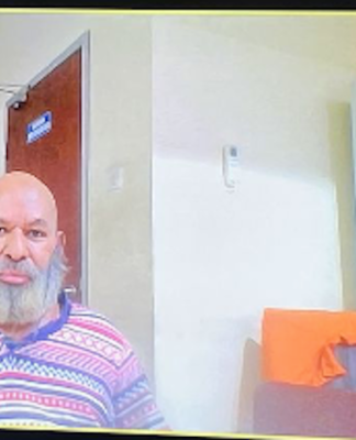 Papua Governor, Lukas Enembe on a video monitor