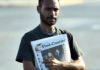 A PNG Post-Courier newsboy on the streets in Port Moresby