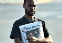 A PNG Post-Courier newsboy on the streets in Port Moresby