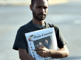 A PNG Post-Courier newsboy on the streets in Port Moresby