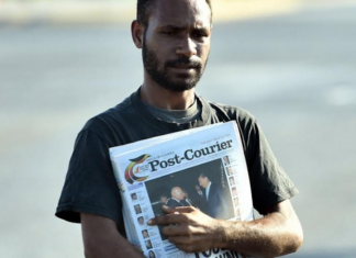 A PNG Post-Courier newsboy on the streets in Port Moresby
