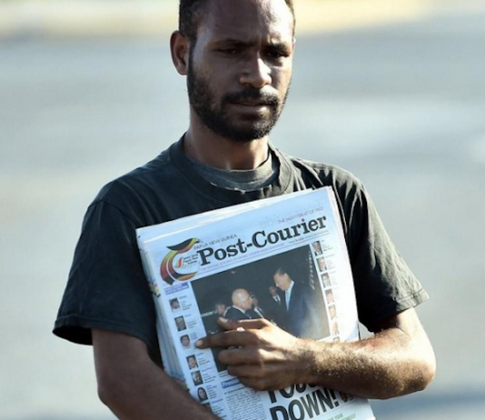 A PNG Post-Courier newsboy on the streets in Port Moresby