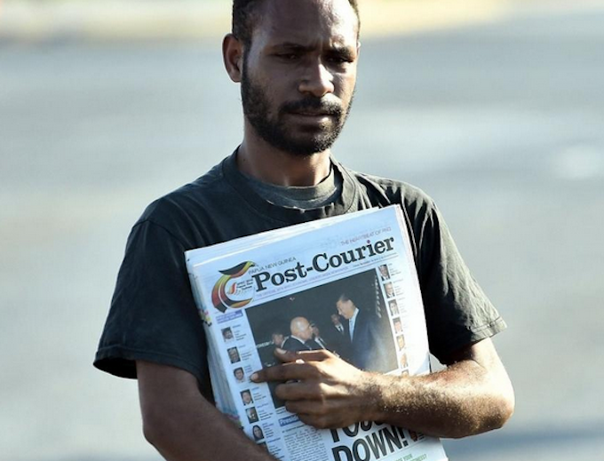 A PNG Post-Courier newsboy on the streets in Port Moresby