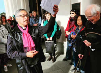 Activist minister Reverend Mua Strickson-Pua brandishes the petition against the AUKUS military pact at the launch