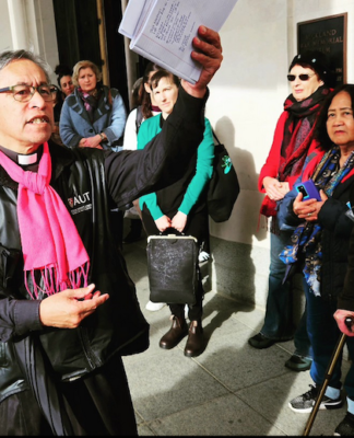 Activist minister Reverend Mua Strickson-Pua brandishes the petition against the AUKUS military pact at the launch