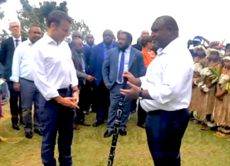 Prime Minister James Marape presenting a traditional eagle wood spear with totems to French President Emmanuel Macron