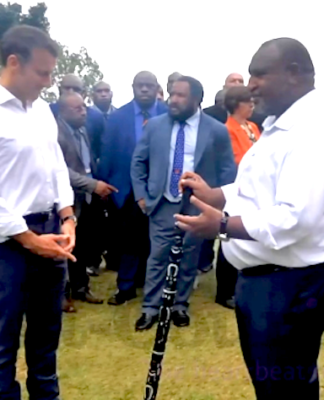 Prime Minister James Marape presenting a traditional eagle wood spear with totems to French President Emmanuel Macron