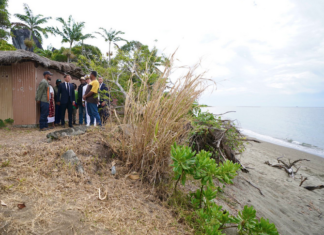 French President Emmanuel Macron visits Kanak villagers yesterday in an area near Tuoho