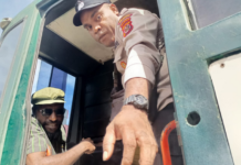 Victor Yeimo (seated and wearing glasses), in a detention vehicle after attending a treason trial at Jayapura District Court, on 4 July 2023