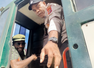 Victor Yeimo (seated and wearing glasses), in a detention vehicle after attending a treason trial at Jayapura District Court, on 4 July 2023