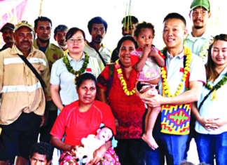 Dr Liu (second from right) visits baby Taylor (cradled by his mother)