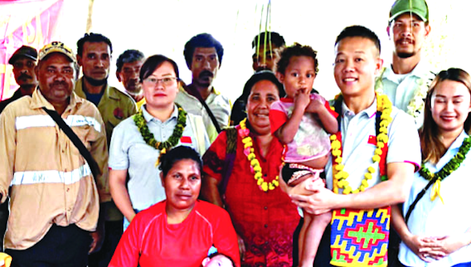 Dr Liu (second from right) visits baby Taylor (cradled by his mother)