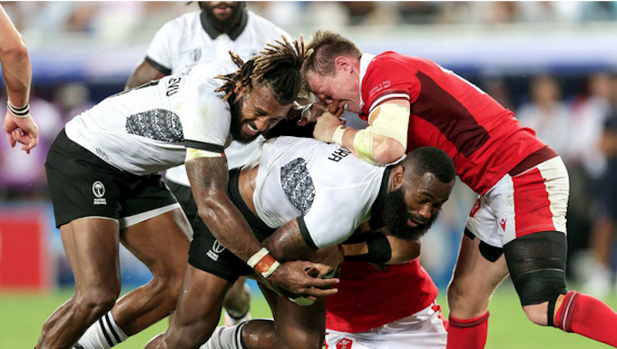 Fiji's Semi Radradra and Waisea Nayacalevu with Nick Tompkins of Wales