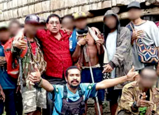 The controversial photo of Milne Bay Governor Gordon Wesley (red shirt) and gang leader Eugene Pakailasi (blue shirt)