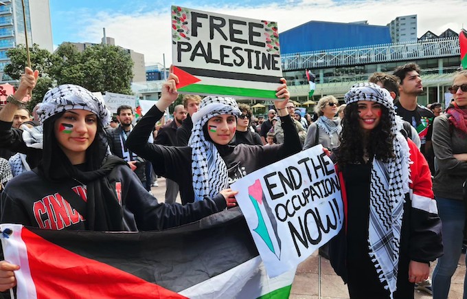 "End the occupation now" says a placard held by these young Palestinian women protesters