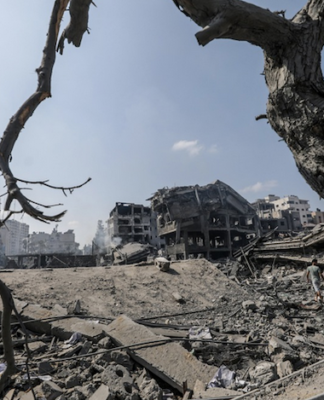 Palestinians walk amid the rubble of a destroyed area in the Al-Ramal neighborhood in Gaza
