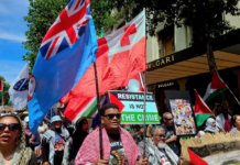 Pro-Palestinian protesters carrying the Fiji and Tongan national flags