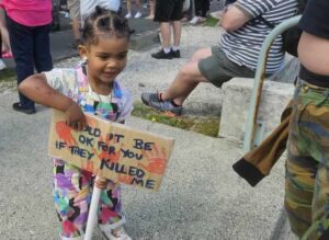 A child carrying a placard protesting 