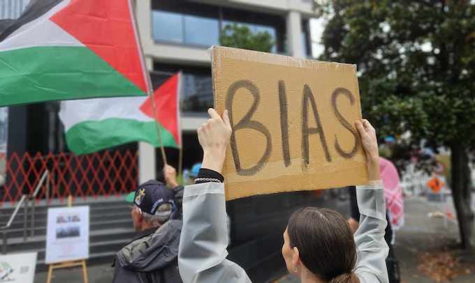 A protester holding up a "Bias" placard outside TVNZ