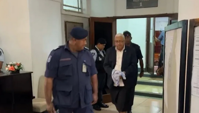 Former Fiji prime minister Voreqe Bainimarama walks out of the Suva High Court escorted by police officers to the be taken to jail today.