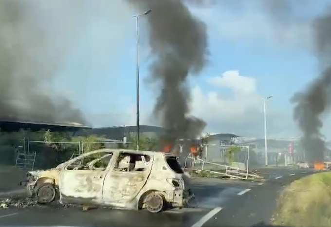 Burning cars at a Nouméa protest barricade today. 