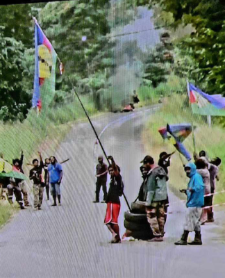 A Kanak protest barricade (in the distance behind the group of protesters) near Nouméa