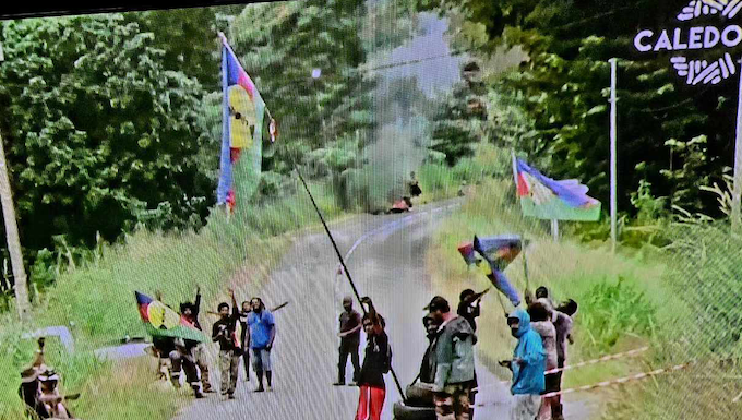 A Kanak protest barricade (in the distance behind the group of protesters) near Nouméa