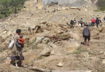 People dig through mud and rocks today after a major landslide at Yambali