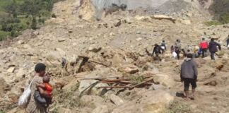 People dig through mud and rocks today after a major landslide at Yambali