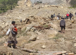 People dig through mud and rocks today after a major landslide at Yambali