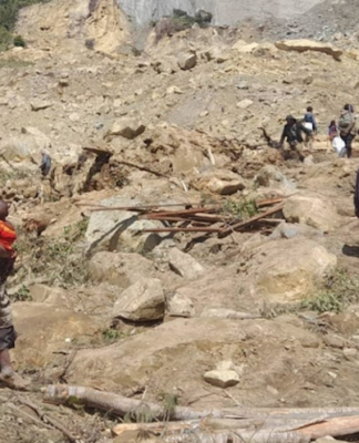 PNG landslide: Thousands on standby for evacuation amid fears of new crisis People dig through mud and rocks today after a major landslide at Yambali
