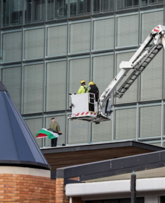 NZ police and firefighters work to get the pro-Palestinian protester with flag down from the roof of Christchurch City Council