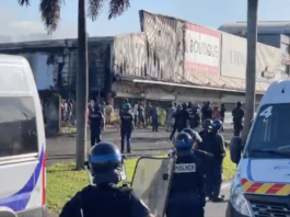 French riot police outside a torched shop in the New Caledonian capital Nouméa