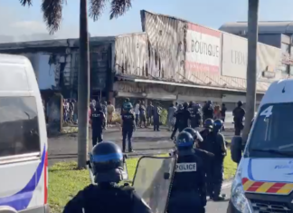 French riot police outside a torched shop in the New Caledonian capital Nouméa