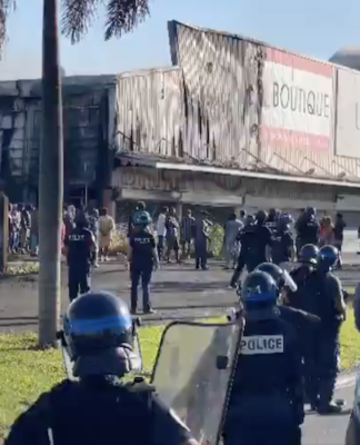 French riot police outside a torched shop in the New Caledonian capital Nouméa