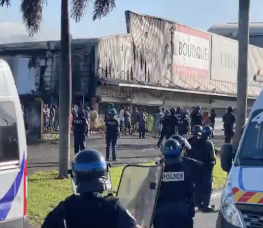 French riot police outside a torched shop in the New Caledonian capital Nouméa
