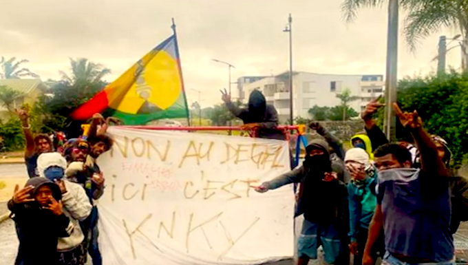 A Kanak pro-independence protester banner declares "No to 'unfreezing' (the electoral rules)"