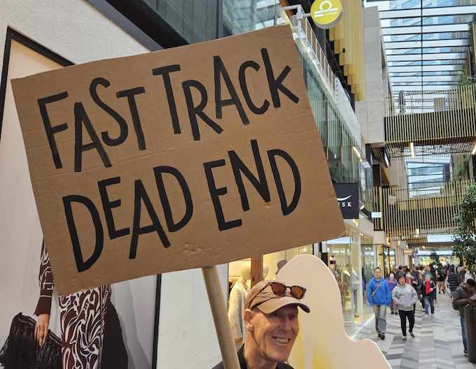 A protester holds a "Fast track dead end" placard