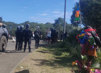 French riot police near the spot - marked with a tribal offering - where 19-year-old Jybril Salo was shot in the back last May.