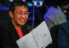 Standing in front of her news organisation’s logo, Rappler chief executive Maria Ressa