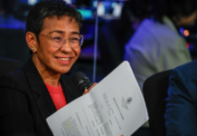 Standing in front of her news organisation’s logo, Rappler chief executive Maria Ressa