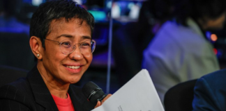 Standing in front of her news organisation’s logo, Rappler chief executive Maria Ressa