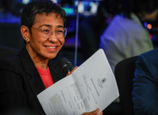 Standing in front of her news organisation’s logo, Rappler chief executive Maria Ressa