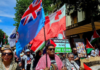 Pacific flags -- Fiji and Tonga -- and protesters in support of Palestine at a rally in New Zealand's largest city Auckland