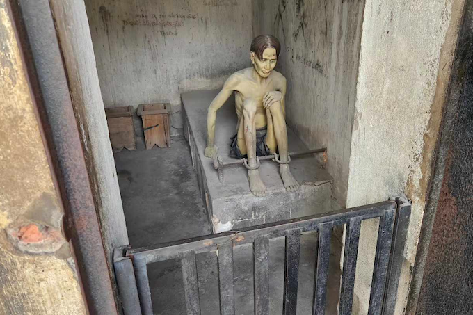 A shackled Viet Cong suspect (mannequin) in a torture "tiger cage"