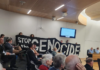 Christchurch citizens hold up a "Stop the genocide" banner before yesterday's council vote