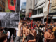 John Miller's photograph of the 1975 Land March held up in the same location at the 2024 Hīkoi mō te Tiriti in Pōneke Wellington.